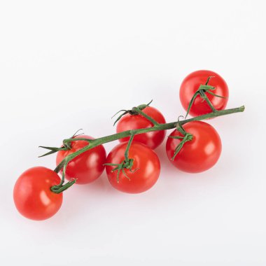 Beyaz arka planda izole edilmiş bir dalda domates.