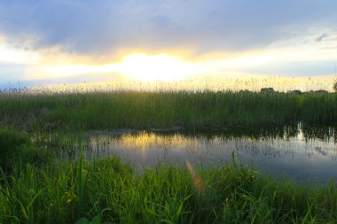 Sakin gölün üzerinde güzel bir gün batımı