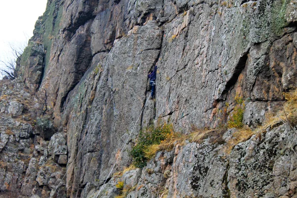 Garçon grimpeur grimpe sur un rocher — Photo