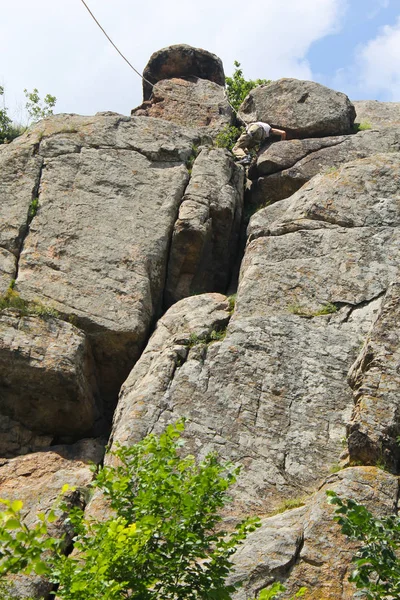 Альпинист, взбирающийся на скалу — стоковое фото