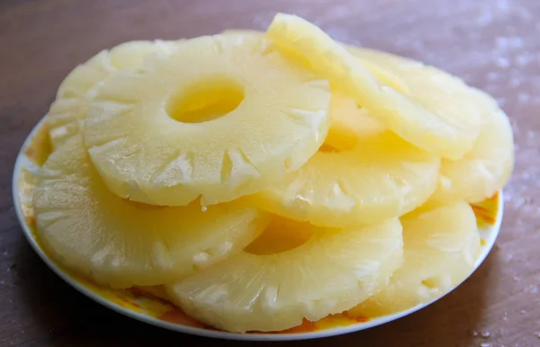 Piña enlatada en un plato sobre una mesa de madera — Foto de Stock