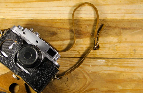 Old retro camera in leather case on wooden background — Stock Photo, Image