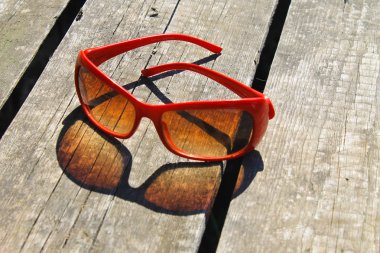 Ahşap arka plan üzerinde kırmızı güneş gözlüğü