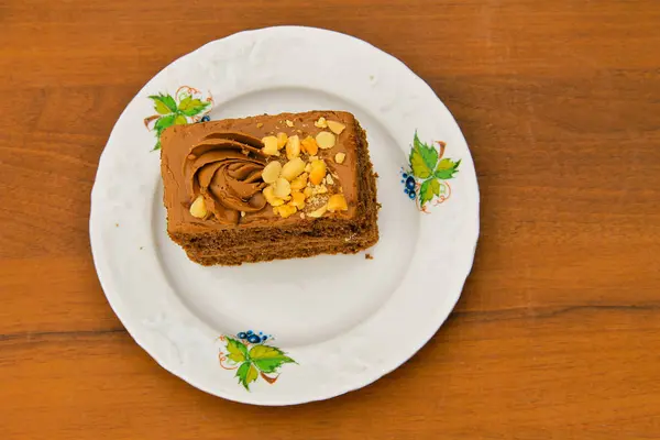 Шматочок торта з горіхами на тарілці на дерев'яному столі. Вид зверху — стокове фото
