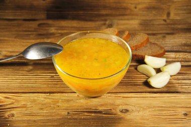 Ahşap masa üzerinde cam kapta taze bezelye çorbası