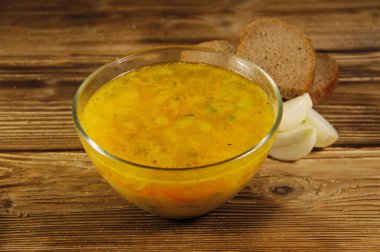 Ahşap masa üzerinde cam kapta taze bezelye çorbası