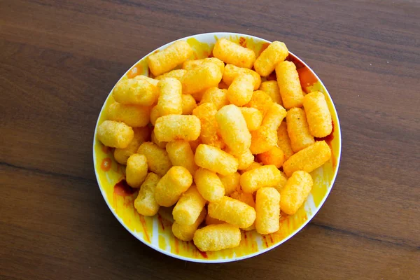 Corn sticks in bowl on wooden table — Stock Photo, Image