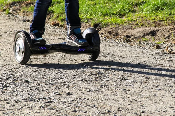 Legs of boy riding on self-balancing mini hoverboard in the city — Stock Photo, Image