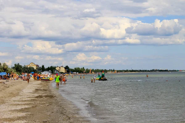 La gente disfruta en la playa del Mar Negro en la aldea de Rybakivka — Foto de Stock