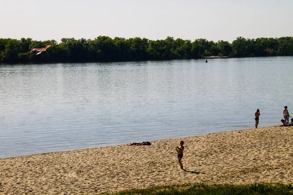 Small boy launch a kite on sandy beach at river — Stock Photo, Image