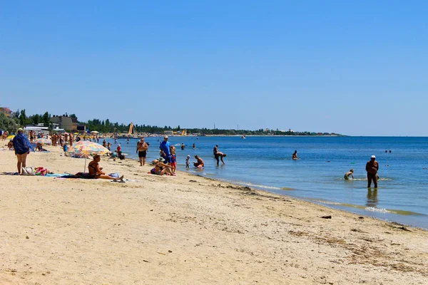 La gente disfruta en la playa del Mar Negro en la aldea de Rybakivka — Foto de Stock