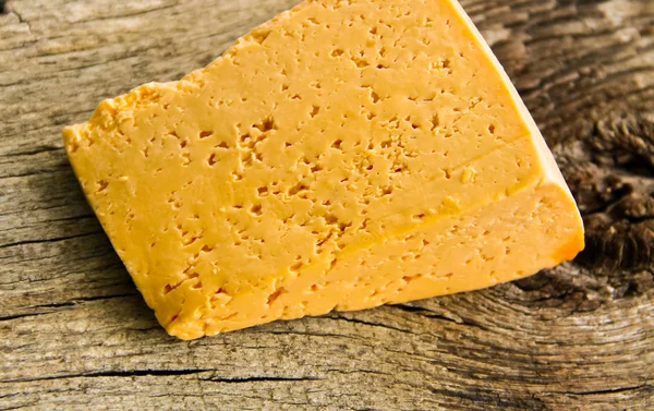 Piece of cheese on a wooden background — Stock Photo, Image