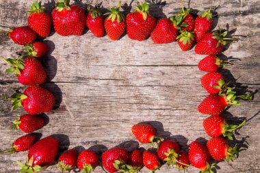 Çerçeve ahşap masa üzerinde taze kırmızı çilek