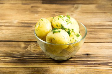 Tereyağı ve ahşap masa üzerine dereotu ile yeni haşlanmış patates