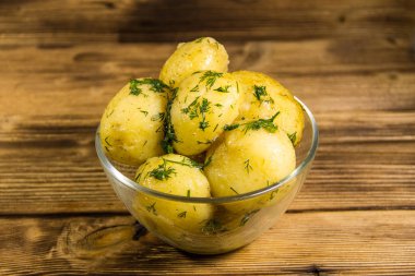 Tereyağı ve ahşap masa üzerine dereotu ile yeni haşlanmış patates