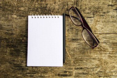Not Defteri, gözlük ve kalem eski ahşap masa