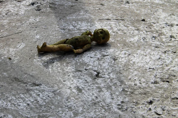 灰色のコンクリート床に放棄された古い壊れた人形 — ストック写真