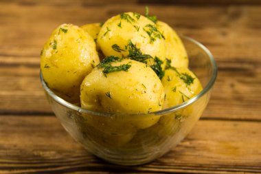 Tereyağı ve ahşap masa üzerine dereotu ile yeni haşlanmış patates