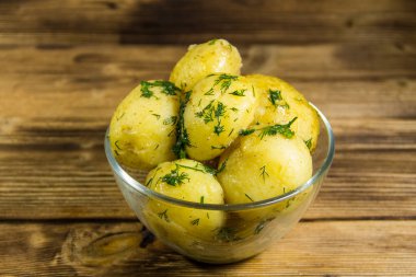 Tereyağı ve ahşap masa üzerine dereotu ile yeni haşlanmış patates