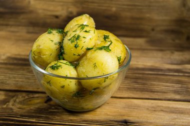 Tereyağı ve ahşap masa üzerine dereotu ile yeni haşlanmış patates