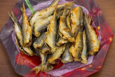 Ahşap arka plan üzerine bir tabak kızarmış Baltık ringa