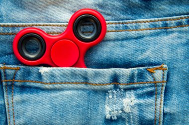 Kırmızı kıpır spinner stres giderici oyuncak mavi kot pantolon cebinde