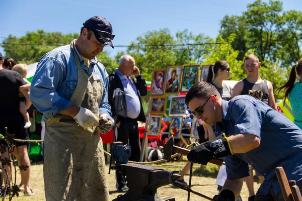 Genç bir adam sanatı deneyimli demirci öğretir