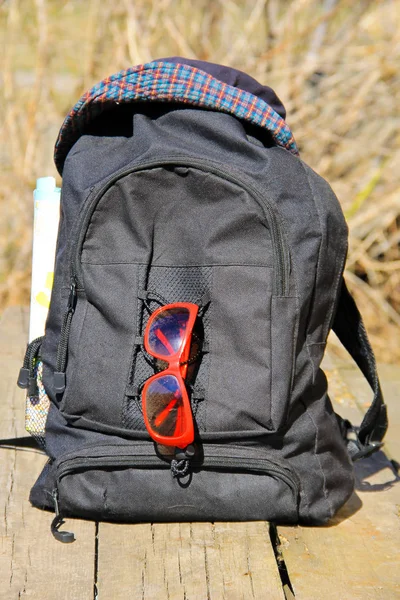 Şapka, kırmızı güneş gözlüğü ile sırt çantası ve harita