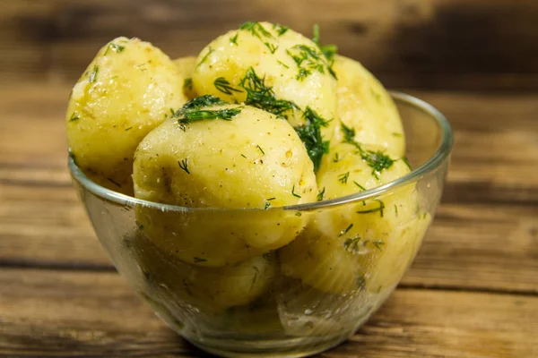 Tereyağı ve ahşap masa üzerine dereotu ile yeni haşlanmış patates