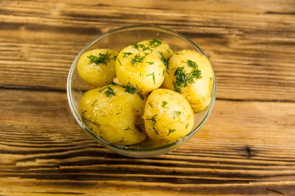 Vařené nové brambory s máslem a kopr na dřevěný stůl — Stock fotografie
