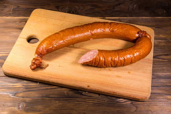 Räucherwurst auf Schneidebrett auf Holztisch — Stockfoto