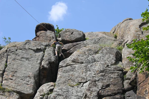 女性ロッククライマーが岩の上に登る — ストック写真