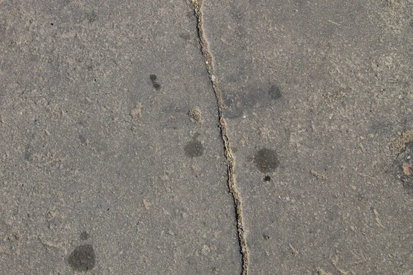 Textura s prasklinami na asfaltovém pozadí — Stock fotografie