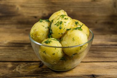 Tereyağı ve ahşap masa üzerine dereotu ile yeni haşlanmış patates