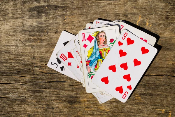 Playing cards on old wooden table — Stock Photo, Image
