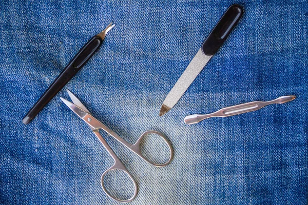 Basic set of manicure tools on jeans background