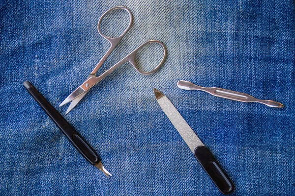 Основной набор маникюрных инструментов на фоне джинсов — стоковое фото