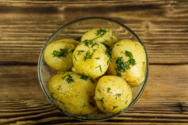 Tereyağı ve ahşap masa üzerine dereotu ile yeni haşlanmış patates