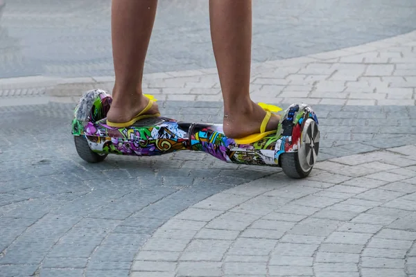 Las piernas de la muchacha que monta en auto-equilibrio mini hoverboard en la calle de la ciudad —  Fotos de Stock