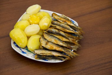 Fried Baltık Ringa balığı bir plaka üzerinde haşlanmış patates ile
