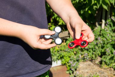 Çocuk iki topluca spinner ile oynarken stres giderici oyuncaklar 