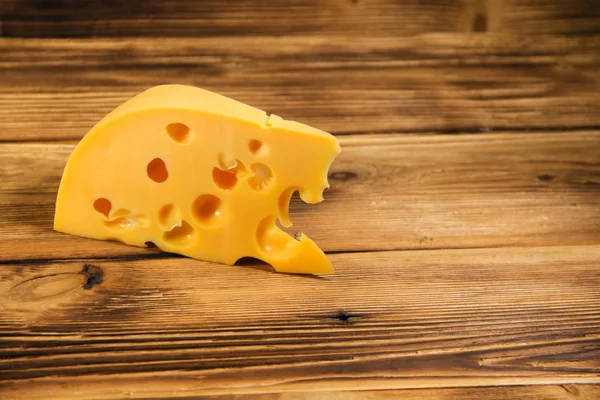 Pedaço de queijo sobre fundo de madeira — Fotografia de Stock