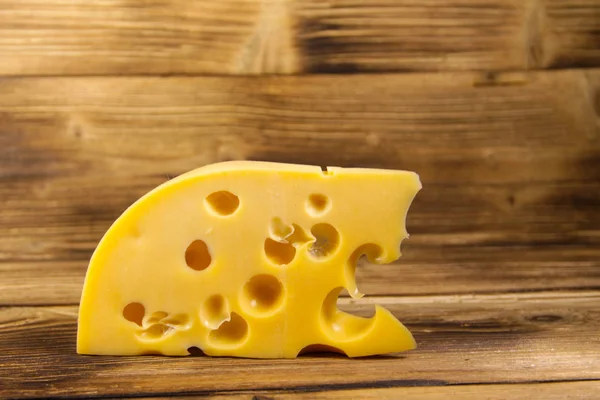 Pedaço de queijo sobre fundo de madeira — Fotografia de Stock