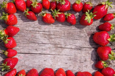 Çerçeve ahşap masa üzerinde taze kırmızı çilek 