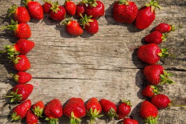 Çerçeve ahşap masa üzerinde taze kırmızı çilek 