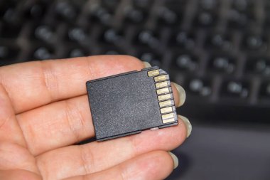 SD kartı laptop arka planda tutan el