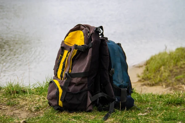 Два туристических рюкзака на берегу реки — стоковое фото