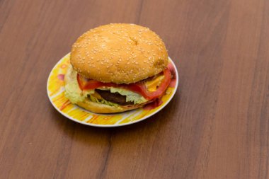 Lezzetli hamburger veya sandviç ahşap masa üzerinde plaka üzerinde