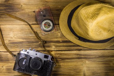 Ahşap arka plan üzerinde Pusula, şapka ve retro fotoğraf makinesi