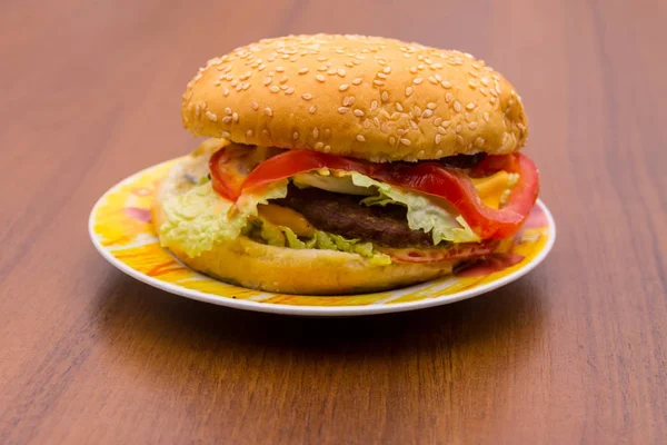 Lahodný hamburger nebo sendvič na štítku na dřevěný stůl — Stock fotografie